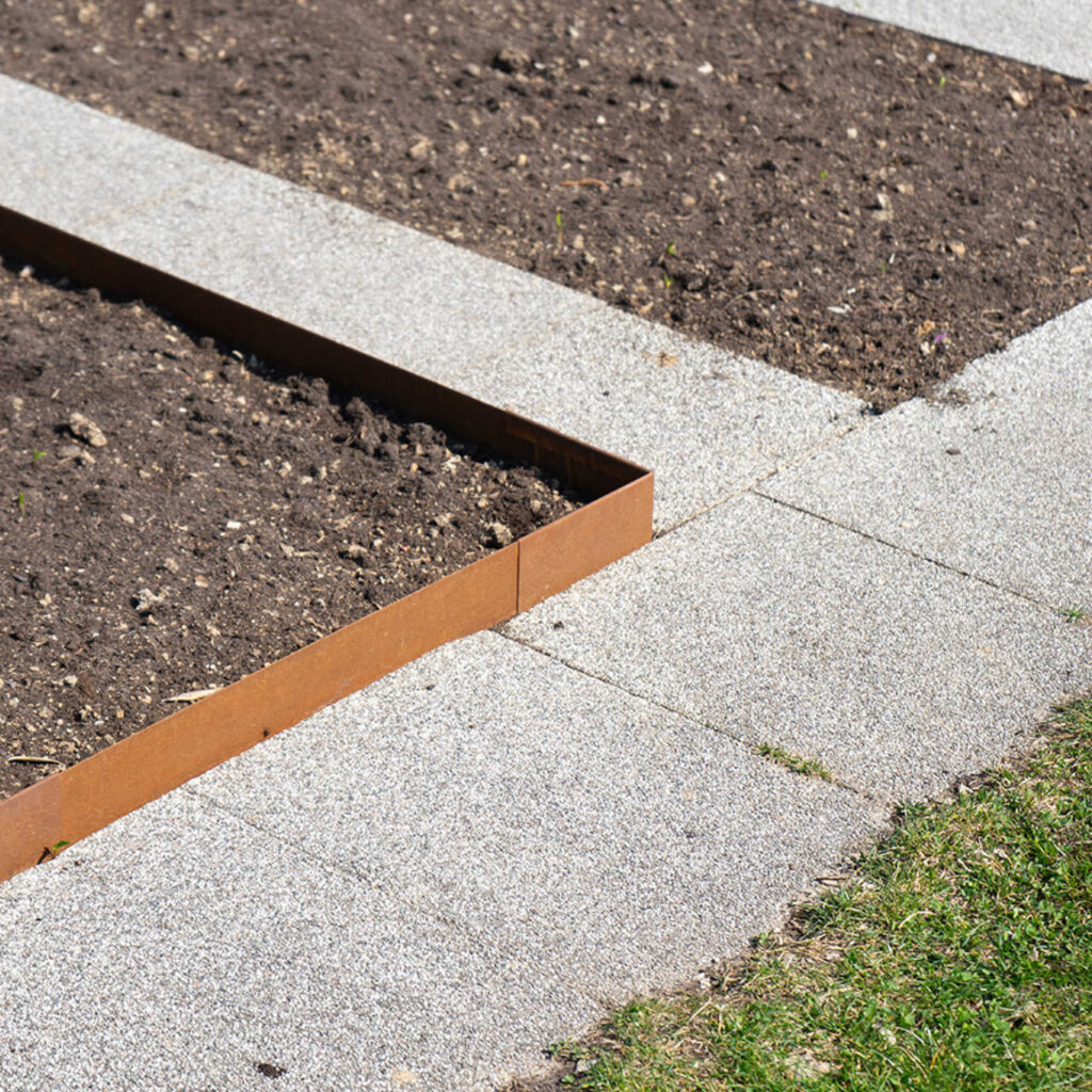Beeteinfassung aus Cortenstahl als rostige Gartenabgrenzung für strukturierte Beete.